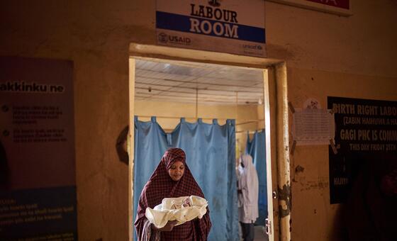 在尼日利亚索科托州一家医院的分娩室里，一名妇女怀抱她刚刚出生的孩子。